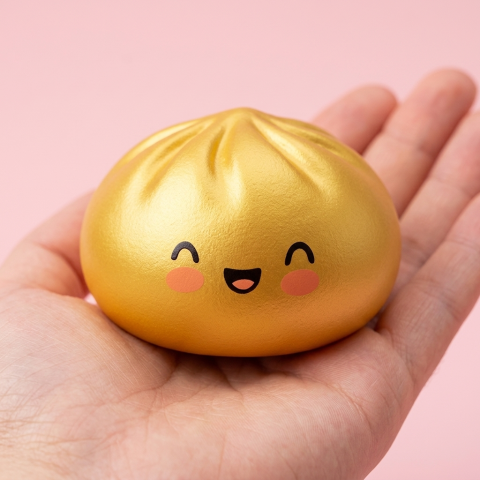 Dumpling Squishy Lucky Gold – Slow Rise Bun in der Hand gehalten, echte Größe