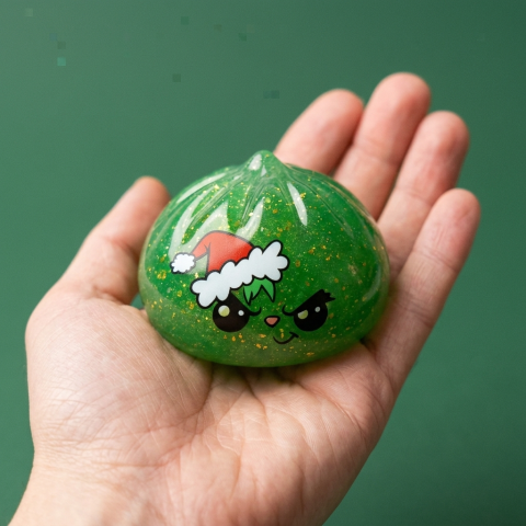 Glitter Dumpling Squishy Weihnachts-Miesepeter Grün in der Hand gehalten, echte Größe