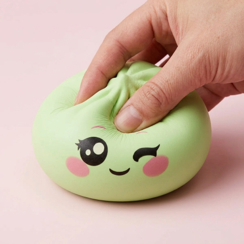 Dumpling Squishy Pistaziengrün mit Zwinkergesicht — slow-rise Effekt, der Schaum federt langsam zurück
